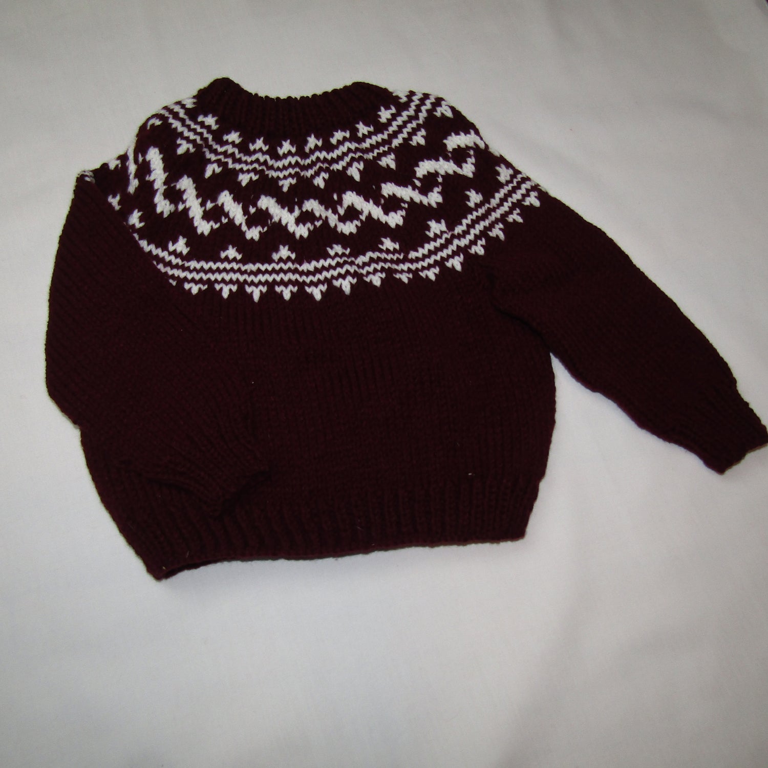 Children's hand knitted wine color fairisle sweater with white collar area. 